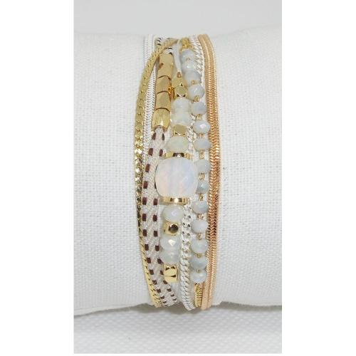 Bracelet multirangs. Il est composé de 7 rangs avec une chaîne en acier chirurgical doré à l'or fin, des fils dans un camaieu de blanc avec des perles de couleur blanc et or.